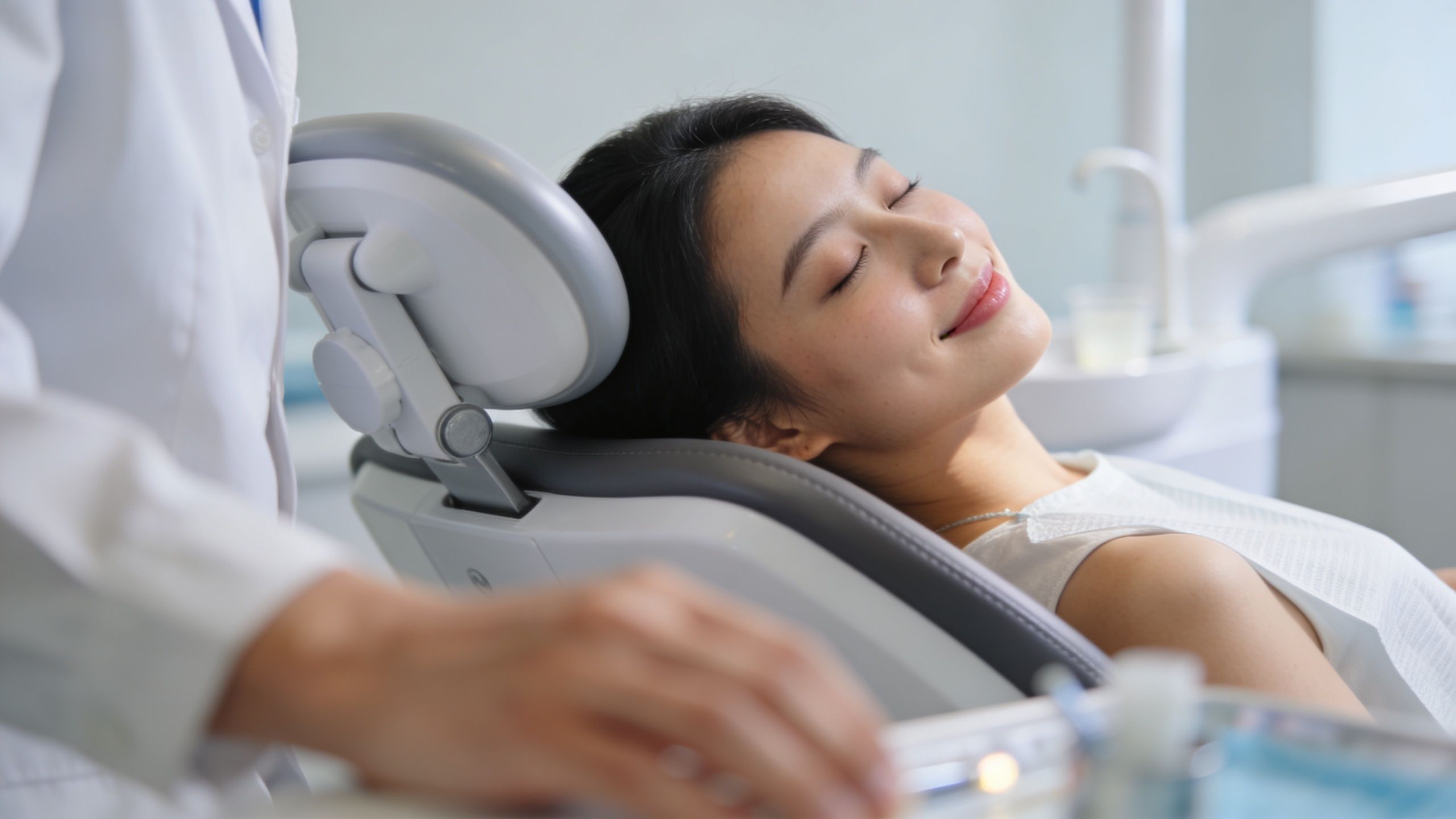 A relaxed patient receiving intravenous sedation in a dental chair during a clinical procedure.