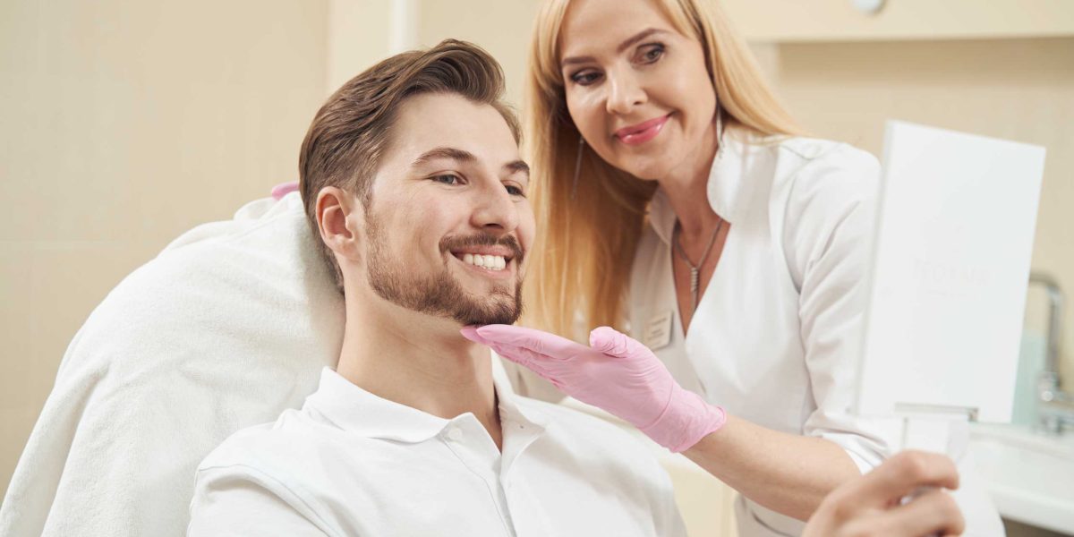 male-beauty-clinic-patient-smiling-into-handheld-m-2023-11-27-05-36-09-utc